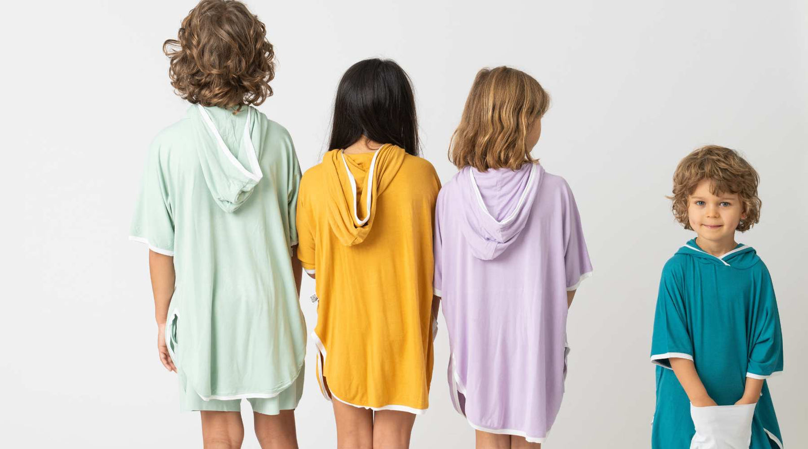 Picture of a child on the beach playing with a truck on the sand, wearing a bamboo t-shirt and matching bamboo shorts in light green colour